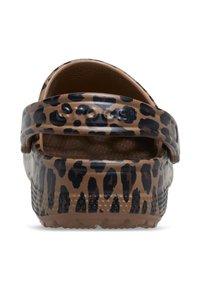 Leopardprint klompen gemaakt van glanzend bruin materiaal, met een brede band en een gestructureerde zool met een bubbulaire patroon.