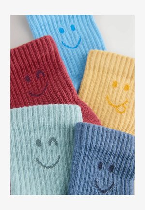 Farverige ribstribede sokker i blå, rød, gul og grøn, hver med et smilende ansigtsdesign. Blødt, tekstureret stof med et legende udseende.