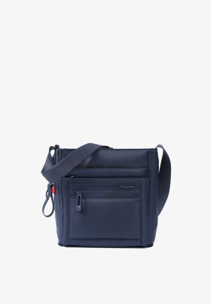 Navyblå crossbody taske med justerbar bred strop, lynlåslomme foran og lille rødt accent ved siden af lynlåstrækket.