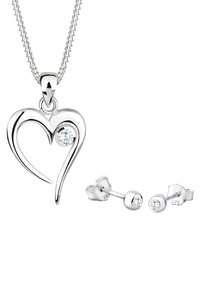Sølv hjertevedhængs halskæde med en cubisk zirkonia akcent, sammen med matchende stud øreringe, der har runde cubiske zirkonia sten.