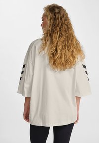 Overdreven grote cr�èmekleurige katoenen t-shirt met zwarte drie-stripes accenten op de mouwen, ronde onderkant en verlaagde schouders.