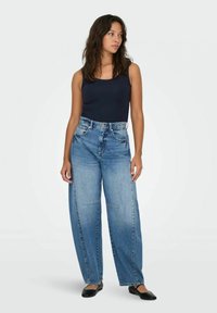 Jeans in denim blu a gamba larga con vita alta, caratterizzati da un classico design a cinque tasche e dettagli sbiaditi delicati, indossati con un top aderente nero.