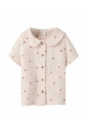 Blouse rose clair à manches courtes avec col claudine, boutonnée devant, deux poches, tissu texturé et petit motif de fraises rouges sur toute la surface.