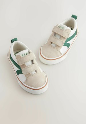 Baskets beiges et blanches avec des accents verts, embout en cuir suédé, deux bandes Velcro, et une semelle blanche texturée, dotée d'une petite languette au talon.