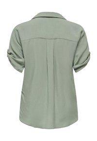 Blusa verde chiaro, con colletto, maniche corte arrotolate con dettagli di bottone e una texture liscia. Il retro presenta un yoke e dettagli a pieghe.