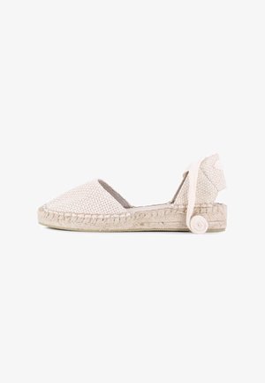 Espadrille de color beige tejido con puntera redondeada, suela de yute trenzado y cinta de tela atada al tobillo adornada con un acento enrollado en la parte posterior.