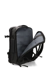 Mochila negra con una abertura con cremallera, presentando un interior a rayas azul y blanco, correas de hombro acolchadas y bolsillos de malla en los laterales.