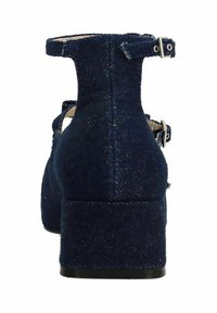 Donkerblauwe denim hakken met een ronde neus en enkelbandje, uitgerust met dubbele gespen en een blokhakontwerp. Textuurstof voegt visuele interesse toe.