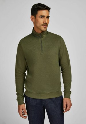 Olivgrüner Pullover mit Viertelreißverschluss-Kragen, weicher Textur und geripptem Saum. Verfügt über dezente Markenkennzeichnung auf der Brust und lange Ärmel.
