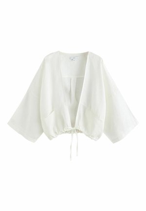 Veste courte blanche à manches kimono, devant ouvert et cordon de serrage ajustable à l’ourlet, en tissu léger.