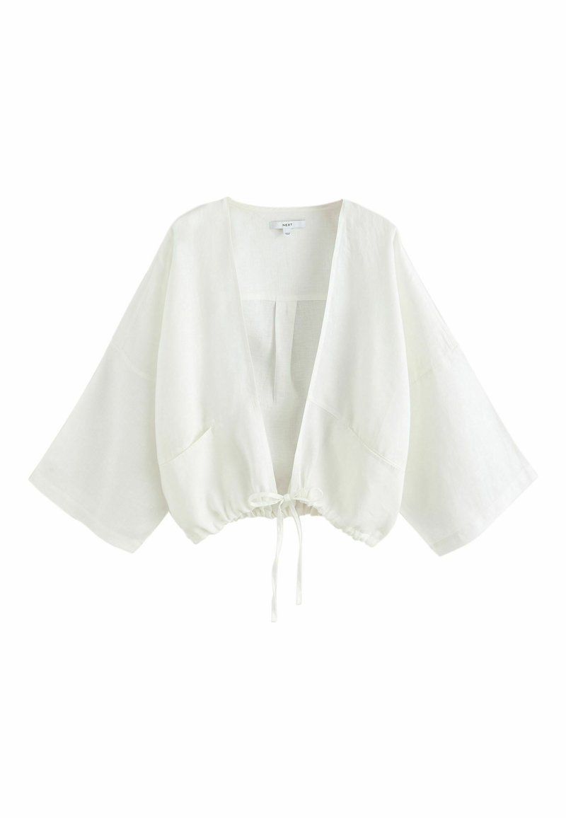 Veste courte blanche à manches kimono, devant ouvert et cordon de serrage ajustable à l’ourlet, en tissu léger.