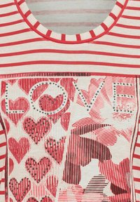 Red and cream striped shirt with a round neckline, featuring a heart-themed graphic with "LOVE" and studded accents. Soft fabric texture.