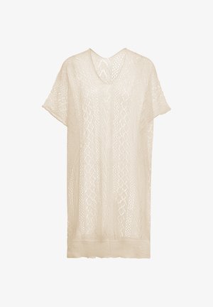 Könnyű bézs kötött tunika V-kivágással és rövid ujjakkal, amely texturált mintázattal és laza, kényelmes szabással rendelkezik.