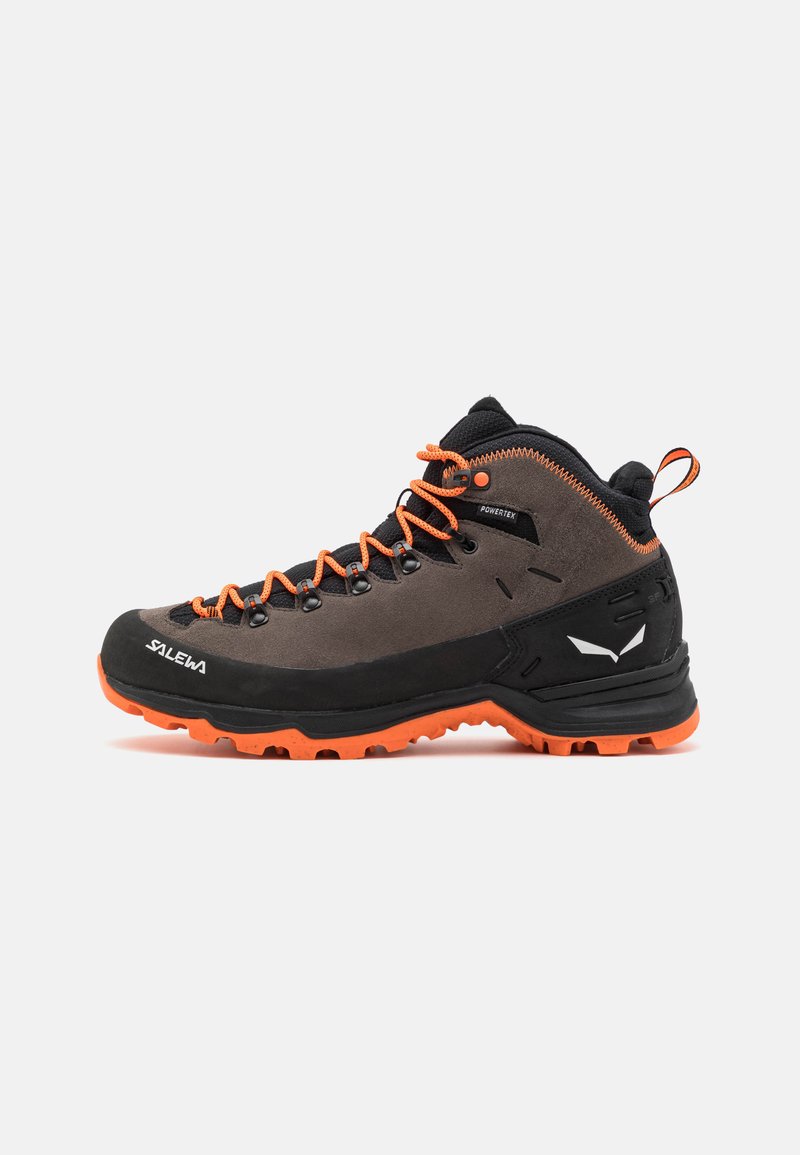 Scarpa da trekking con tomaia in suede grigio scuro, lacci arancioni vivaci e suola in gomma nera. Presenta un colletto imbottito e un dettaglio logo laterale.
