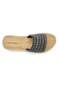 Black slide sandal with repeated white text. Soft upper strap and wooden insole with engraved brand name. Flat, open-toe design.