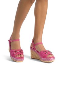 Sandali con zeppa in suede rosa, con punta aperta, dotati di decorazioni a catena, cinturino alla caviglia regolabile e piattaforma intrecciata.