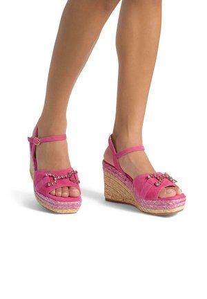 Sandali con zeppa in suede rosa, con punta aperta, dotati di decorazioni a catena, cinturino alla caviglia regolabile e piattaforma intrecciata.