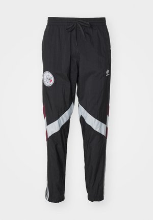 Pantaloni antivento neri con finitura testurizzata, caratterizzati da strisce diagonali in argento e bordeaux, un logo ricamato e una cintura elastica.