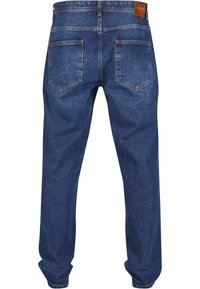 Jeans de mezclilla azul oscuro con un corte relajado, dos bolsillos traseros y una etiqueta de cuero en la cintura. Textura suave, diseño casual.
