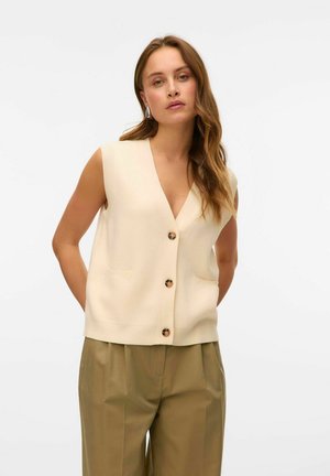 Cream sleeveless cardigan with a V-neck, featuring a button-up front and two front pockets. Soft texture with ribbed accents.