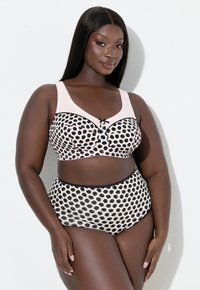 Pilkkukuosinen alusasusetti pehmeässä vaaleanpunaisessa ja mustassa. Settiin kuuluu rintaliivit leveillä olkaimilla ja pienellä rusettikoristeella sekä korkeavyötäröiset alaosat.