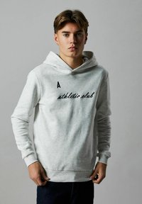 Sweatshirt gris avec capuche, portant le texte brodé noir "A athletic club" à l'avant. Fabriqué en tissu doux et texturé.