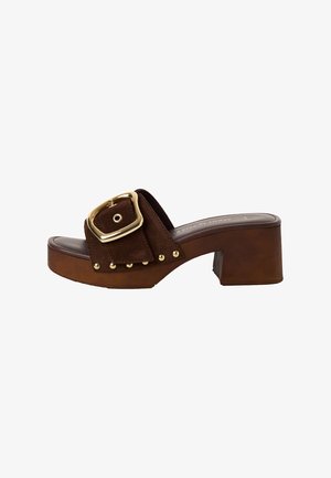 Sandale à enfiler en daim marron avec une large bride, détail de boucle dorée et clous décoratifs. Dispose d'un talon massif marron et d'une semelle intérieure lisse.
