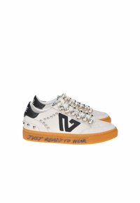 Scarpe da ginnastica con tomaia in pelle bianca, accenti neri, borchie in metallo e strass. Suola in gomma arancione con la scritta "JUST READY TO WEAR".