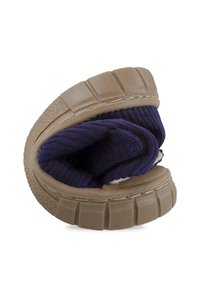 Calzado con un diseño flexible y plegable, con una suela texturizada color marrón y parte superior de tricot azul marino, que presenta un interior suave y peludo.