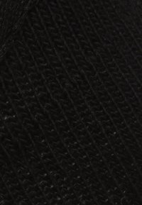 Schwarzer Strickstoff mit geripptem Muster. Das Material wirkt weich und weist deutliche vertikale Linien auf, die durch die Oberfläche verlaufen.