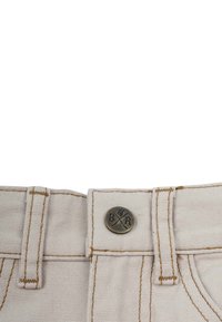Beige tygmidja med metallknapp som har "BR"-logotyp, dekorativ sömnad och bältesöglor. Texturerad yta med en subtil glans.