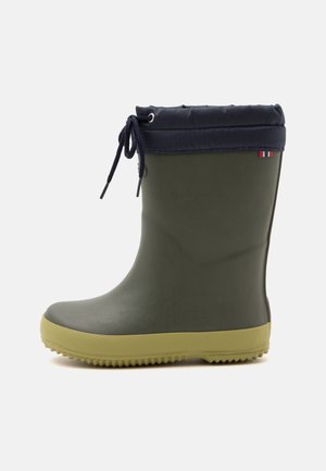 Botte de pluie enfant verte en caoutchouc avec semelle beige et tige rembourrée noire, avec une fermeture à cordon et un petit détail rayé rouge et blanc.