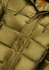 Pufferjack in metallic olijfgroen, met doorgestikte delen, een ritssluiting aan de voorkant, een capuchon met trekkoord en zwarte accenten.