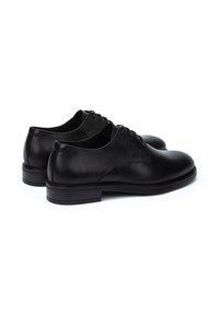 Zapatos de vestir de cuero negro con una textura suave, punta redondeada y detalles de costura mínimos. Presenta un diseño de cordones y una marca sutil.