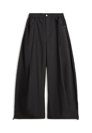 Pantalon large noir à taille haute, avec des plis, une fermeture à bouton sur le devant et deux poches latérales. Fabriqué dans un tissu avec un fini texturé.