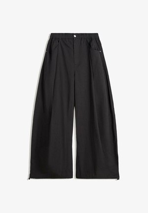 Pantaloni negri cu picioare largi, cu un tiv înalt, având pliseuri, închidere cu un nasture în față și două buzunare laterale. Realizați dintr-un material cu o textură specială.