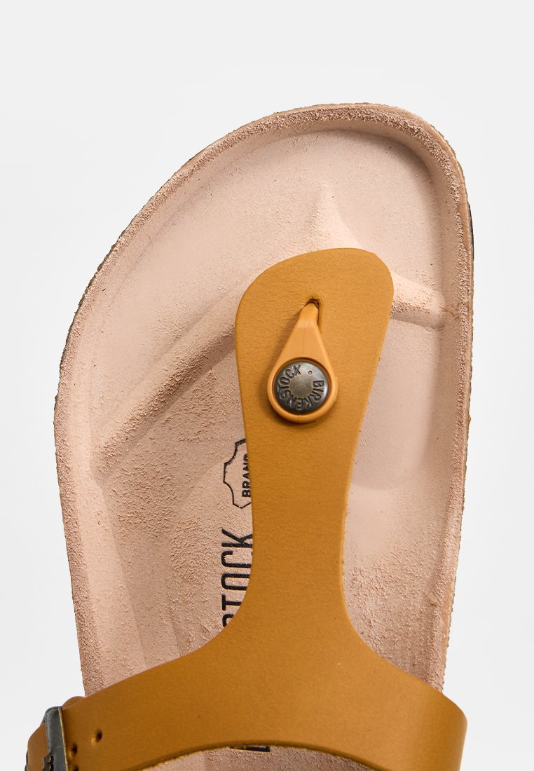 Gelbe Leder-Sandale mit strukturiertem Fußbett und einem abgerundeten Riemen. Verfügt über ein Metallknopf-Detail und Branding auf der Innensohle.