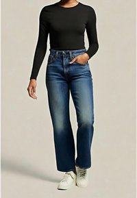 Jean en denim bleu taille haute avec un aspect délavé, comportant cinq poches et une coupe droite. Associé à un haut noir à manches longues et des baskets blanches.