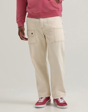 Kremowe spodnie cargo z bocznymi kieszeniami, kontrastowym przeszyciem i luźnym krojem, zestawione z czerwonymi sneakersami z białymi sznurówkami i teksturowaną podeszwą.