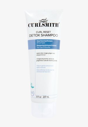 Shampoo détox Curl Reset de Curlsmith dans un tube blanc avec des accents bleus, doté d'un bouchon à charnière. Le texte inclut les ingrédients et les détails d'utilisation.