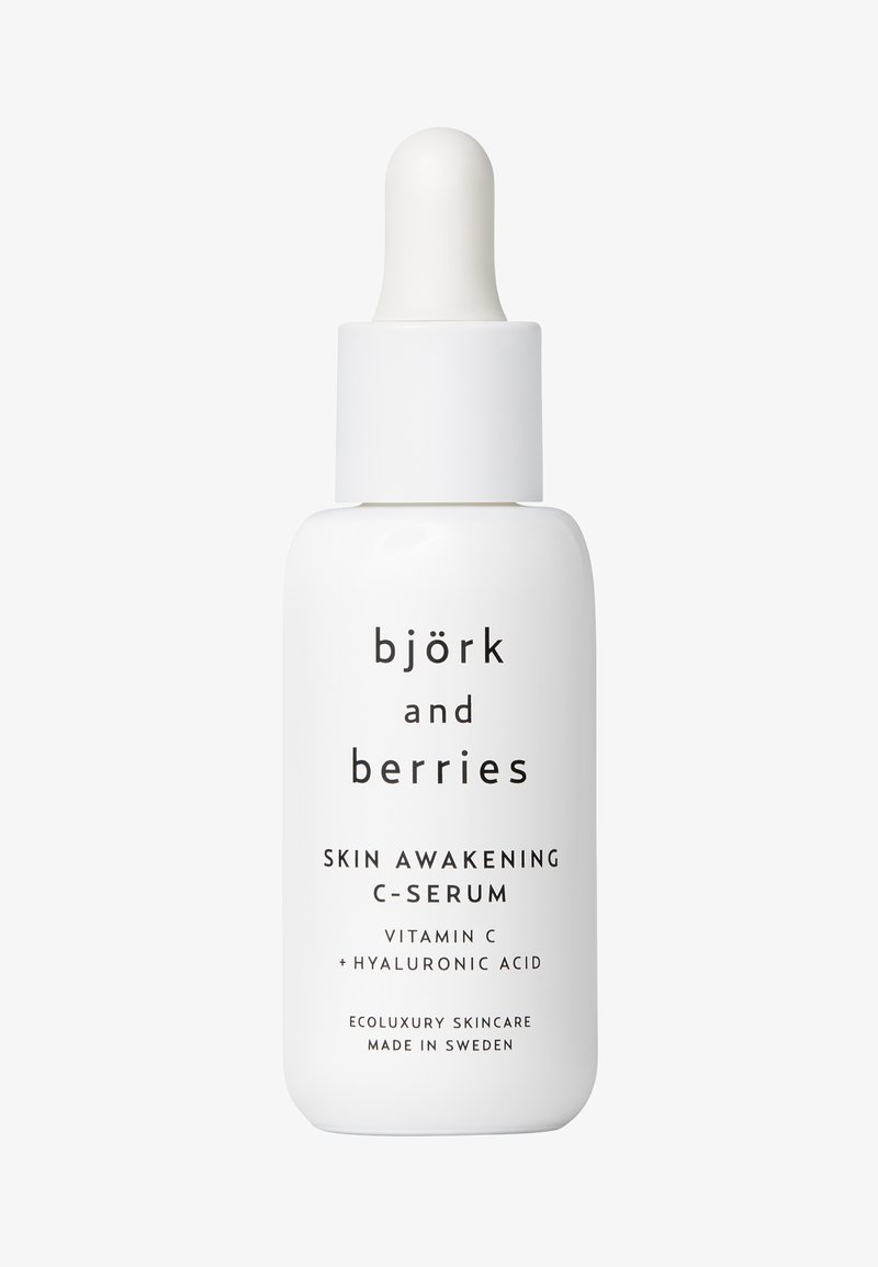 Weiße Glasflasche mit Pipettenverschluss, etikettiert mit "björk and berries SKIN AWAKENING C-SERUM." Verfügt über schlichten schwarzen Text. Umweltfreundliches Design.