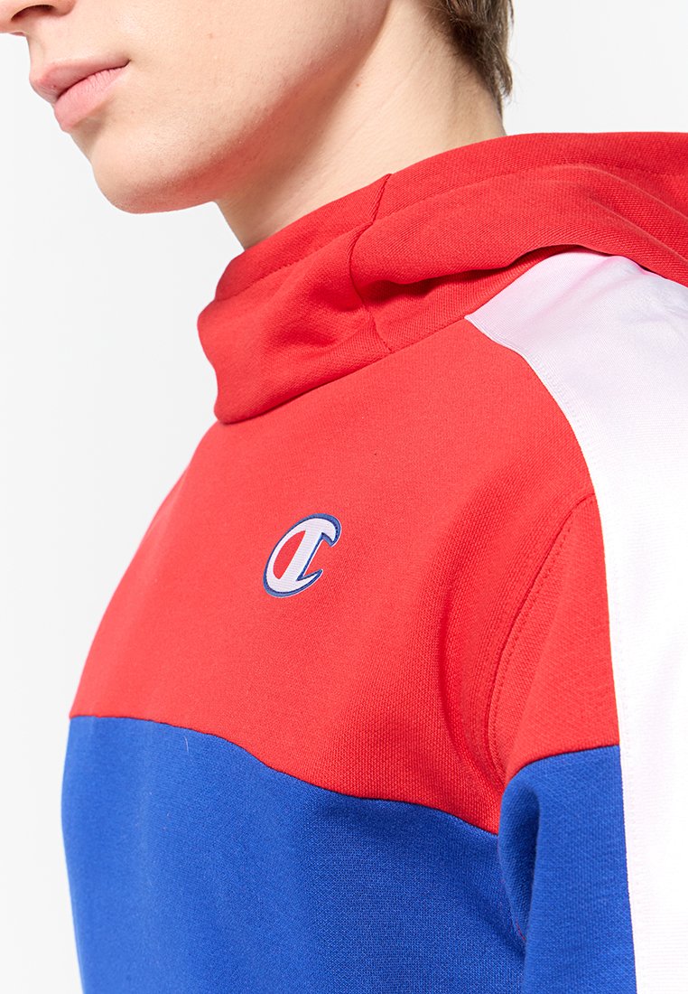 Felpa con cappuccio caratterizzata da blocchi di colore rosso, blu e bianco, realizzata in un tessuto morbido con una struttura a costine. Logo distintivo sul petto.