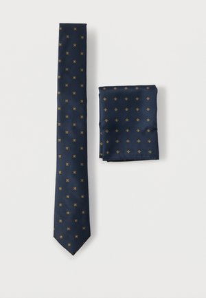 Marineblaues Krawatten- und Einstecktuchset aus Seide mit kleinen goldenen geometrischen Mustern. Glatte Textur mit poliertem Finish.