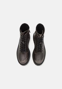 Brune lær ankle boots med en glat finish, sorte snørebånd og lynlåsdetaile på siden, med en robust gummisål.