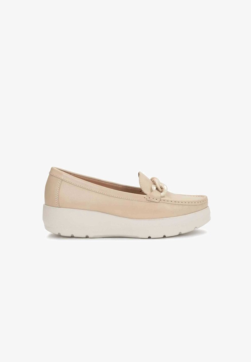 Mocassin en cuir beige avec une semelle blanche épaisse et un nœud décoratif sur le dessus, vu de profil.