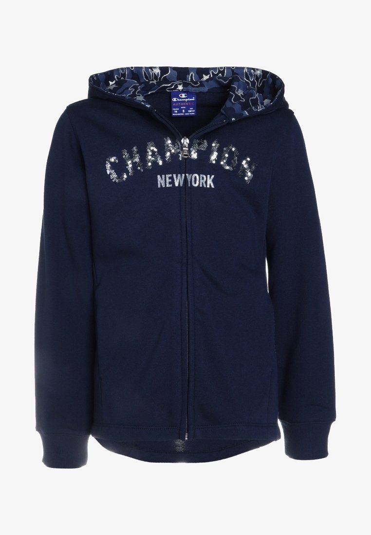 Sweat à capuche zippé bleu marine avec une doublure à capuche camouflage, "CHAMPION NEW YORK" en sequins argentés, et des poignets et ourlet côtelés. Tissu doux.