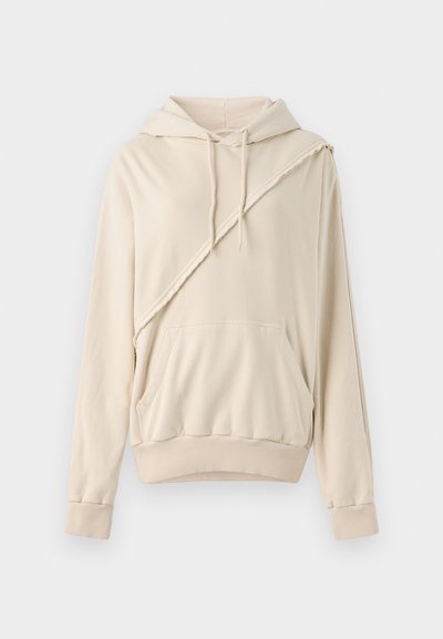 Šviesiai ruda hoodie, pagaminta iš minkštos medžiagos. Išskirtinis bruožas yra įstrižai siūta detalė, priekinė kišenė ir raišteliai bei apykaklė su raukšlėmis.