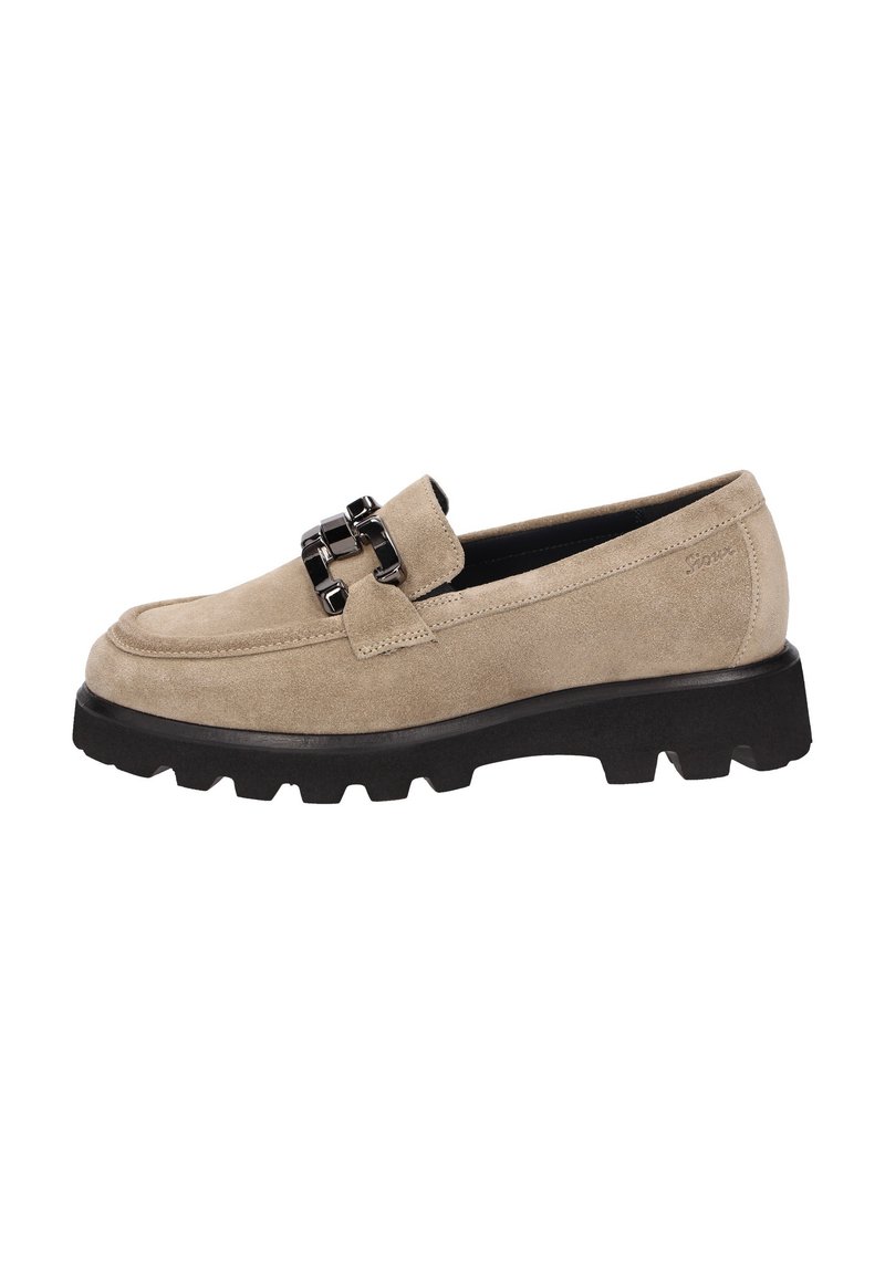 Beige suède instappers met een dikke zwarte rubberen zool, voorzien van een dubbele kettingaccent op de voorkant. Ronde neus en gestikte details.