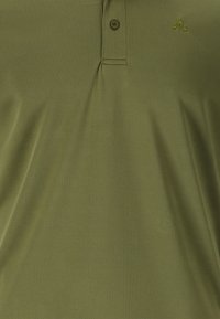 Olivgrön polo skjorta i slätt tyg, med en sydd krage, enstaka knappslå och en liten logotyp i ljusare grönt.