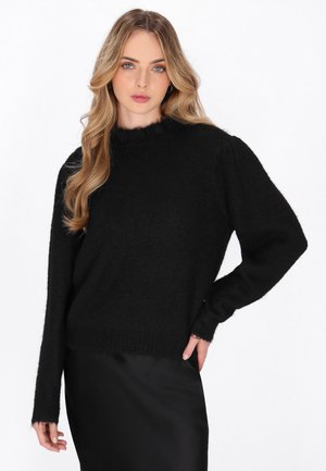 Pull en noir fabriqué à partir d'un matériau doux, avec un col montant, des manches longues et un ourlet légèrement court. Fini texturé.
